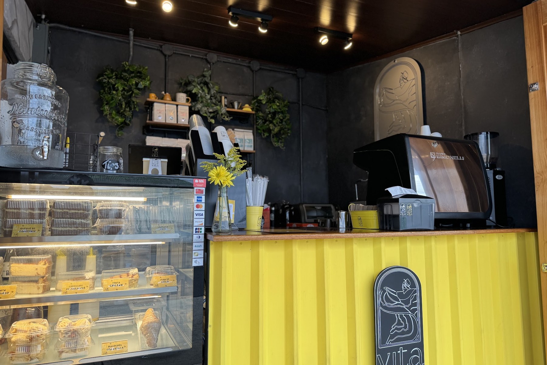 Inside VITA Centro: the yellow counter and pastry case in downtown La Fortuna